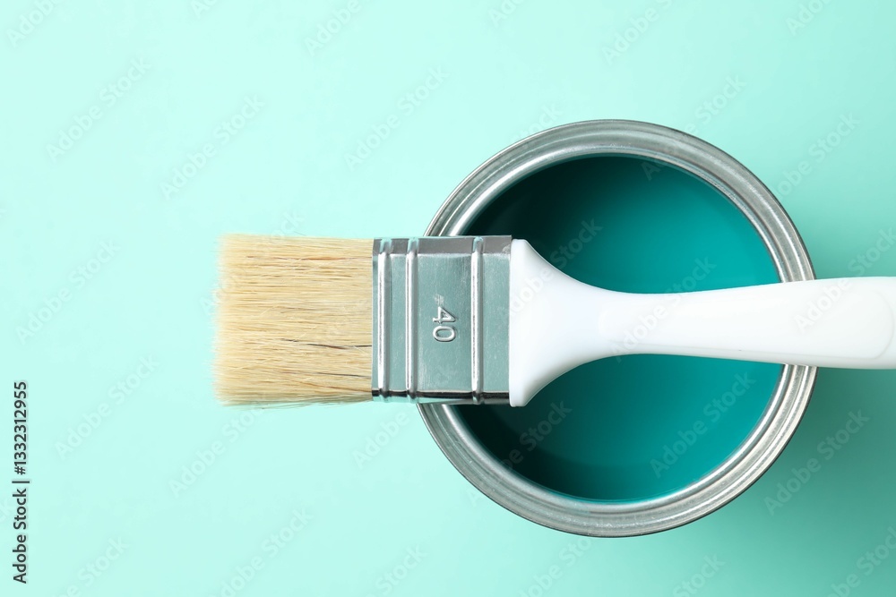 Fototapeta premium Can of bright paint and brush on turquoise background, top view