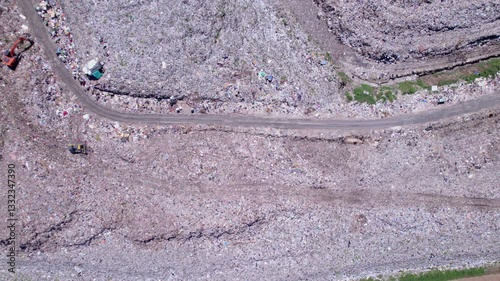 Aerial view of a landfill site filled with various types of waste, including plastic bags, food scraps, rotting fruits, and other discarded materials. Unleagual big garbage dump in Denpasar,  Bali