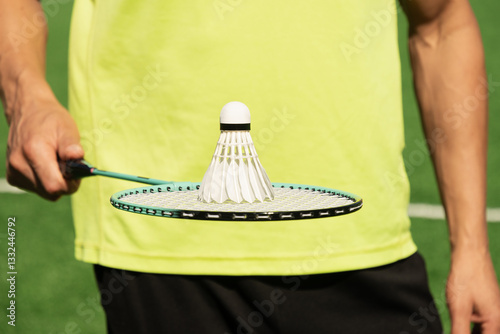 Obraz na płótnie White badminton shuttlecock and badminton rackets in man hands. Summer sports game. Outdoor activity. Close up. w salonie