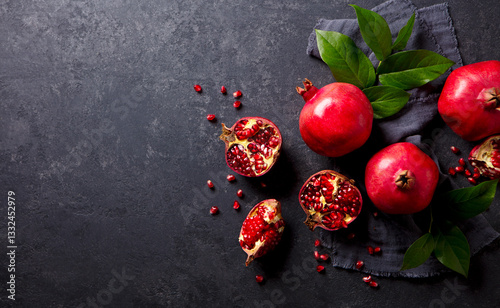 Foto Fresh pomegranates with green leaves on the table