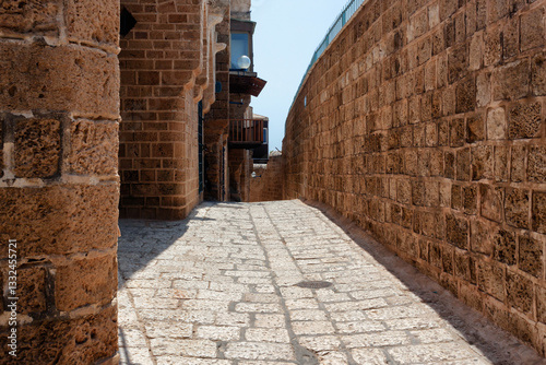 One of the ancient paved narrow historic streets in Old Jaffa on a sunny summer day. Israel.