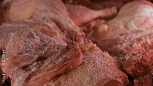 Close-up view of hands in gloves packing chicken legs from a box into individual plastic bags. Process of freezing meat for further use at home. 4k video with light play