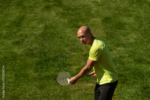 Obraz na płótnie Strong caucasian badminton player racquet hit shuttlecock while practice before competition. Summer sports game, outdoors. Game moment. w salonie