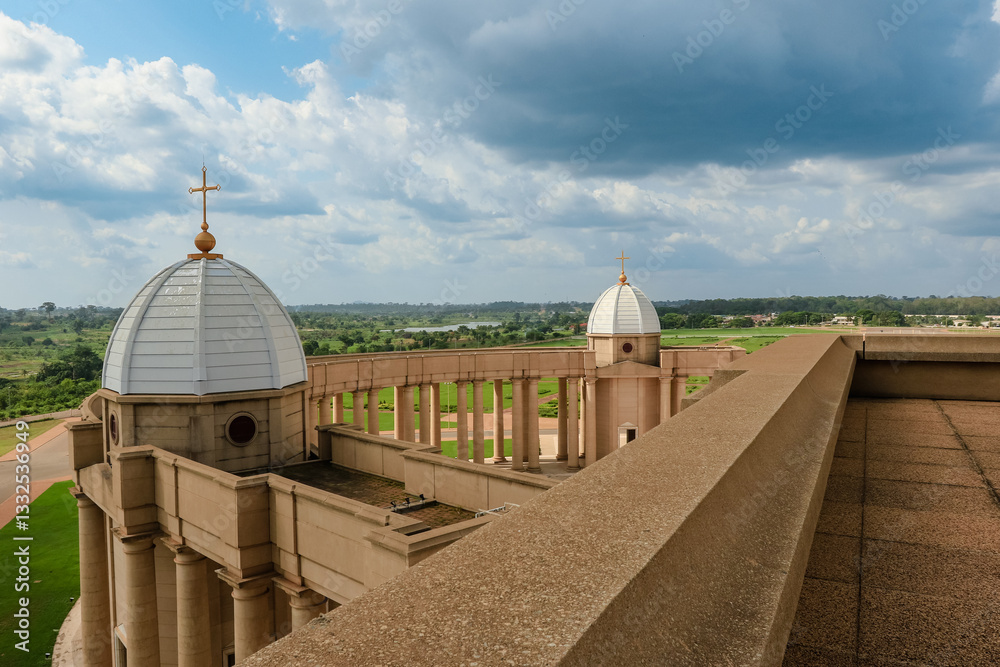 Basilica of Our Lady of Peace overlooks lush Yamoussoukro, Ivory Coast, under clouds