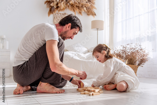 Father and daughter enjoying quality time together, building a structure with wooden blocks in a brightly lit bedroom, fostering creativity and connection