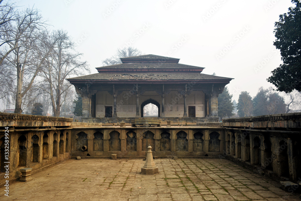 Fototapeta premium Shalimar Bagh's historical pavilion with arched entrance, surrounded by a detailed stone courtyard. Architectural scene, cultural heritage, and travel photography. Serene and timeless beauty
