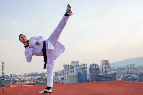 Black belt Taekwondo Player, kicking on top of a building