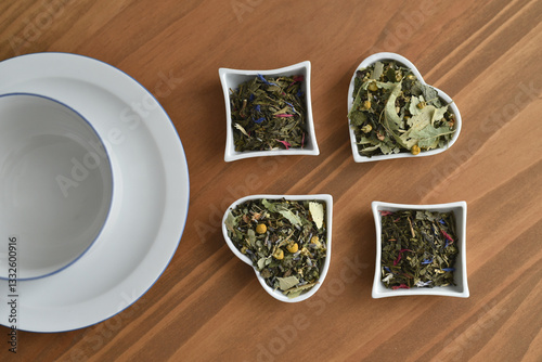 Ingredients for making tea in heart shaped bowls and white cup with saucer