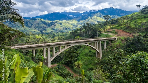 Scenic concrete arch bridge spanning a lush valley nestled in a mountainous region. Lush greenery surrounds the bridge