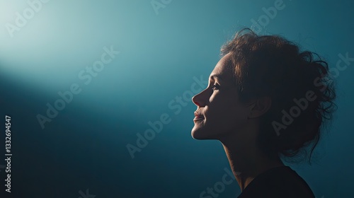 close-up shot of thoughtful individual silhouetted against softly illuminated background symbolizing introspection