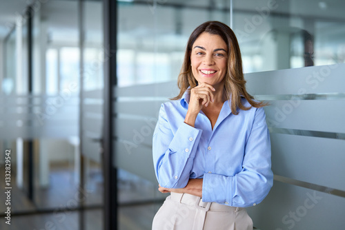Happy middle aged business woman attorney, smiling 45 years old lady entrepreneur, mature female professional executive, bank manager, corporate leader standing in office looking at camera, portrait.