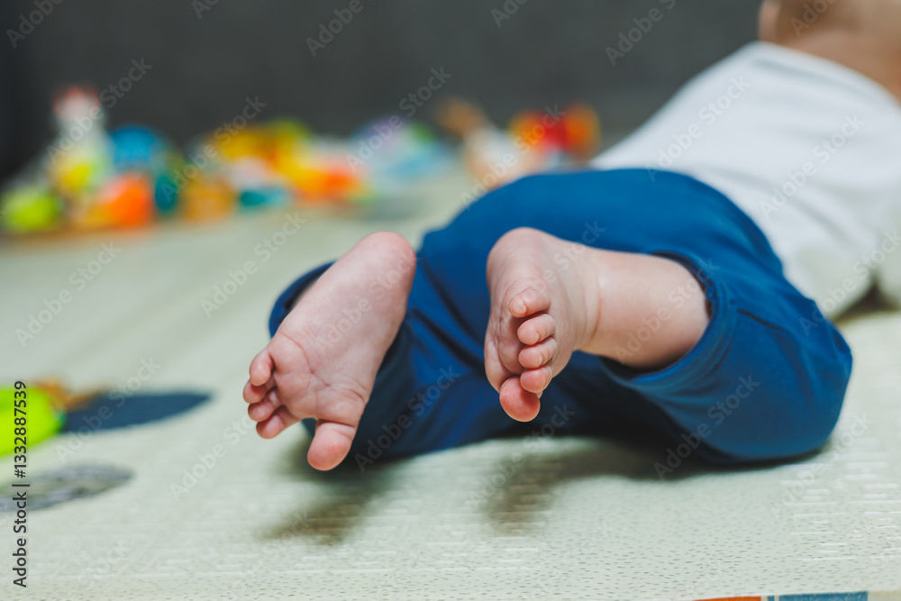 Adorable and Cute Baby Feet Resting on a Colorful Playmat Surrounded by Various Colorful Toys