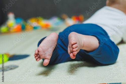 Obraz na płótnie Adorable and Cute Baby Feet Resting on a Colorful Playmat Surrounded by Various Colorful Toys w salonie
