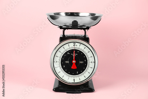One mechanical kitchen scale on pink background photo