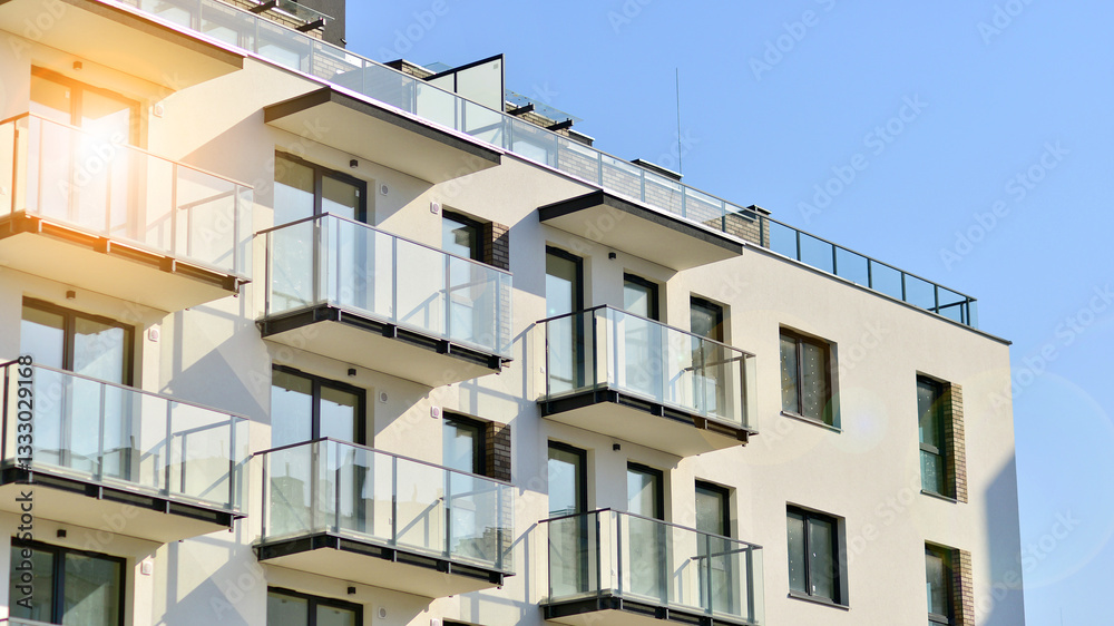 Fototapeta premium Apartment building with symmetrical modern architecture in the city. Modern apartment building on a sunny day. Facade of a modern apartment building. Bottom view. 