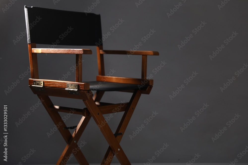 One empty director's chair on grey background, closeup. Space for text One empty director's chair on grey background, closeup. Space for text