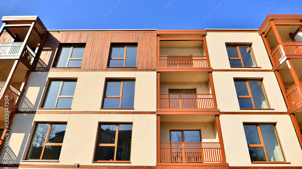 Obraz premium New apartment building. Residential area with modern apartment building. in sunny day. Fragments of the wooden facade.