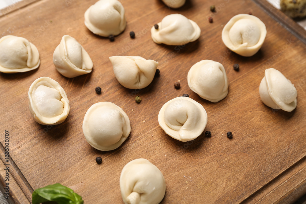 Board with uncooked dumplings on table Board with uncooked dumplings on table