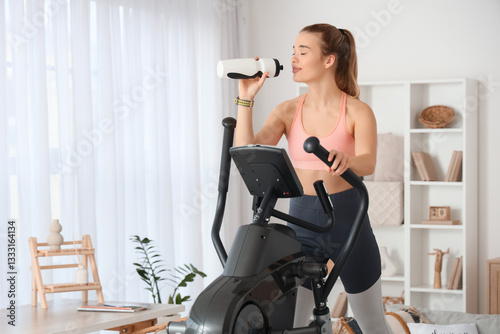 Sporty young woman drinking...