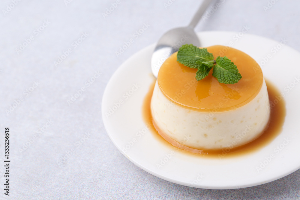 Tasty pudding with caramel sauce served on white table, closeup. Space for text Tasty pudding with caramel sauce served on white table, closeup. Space for text