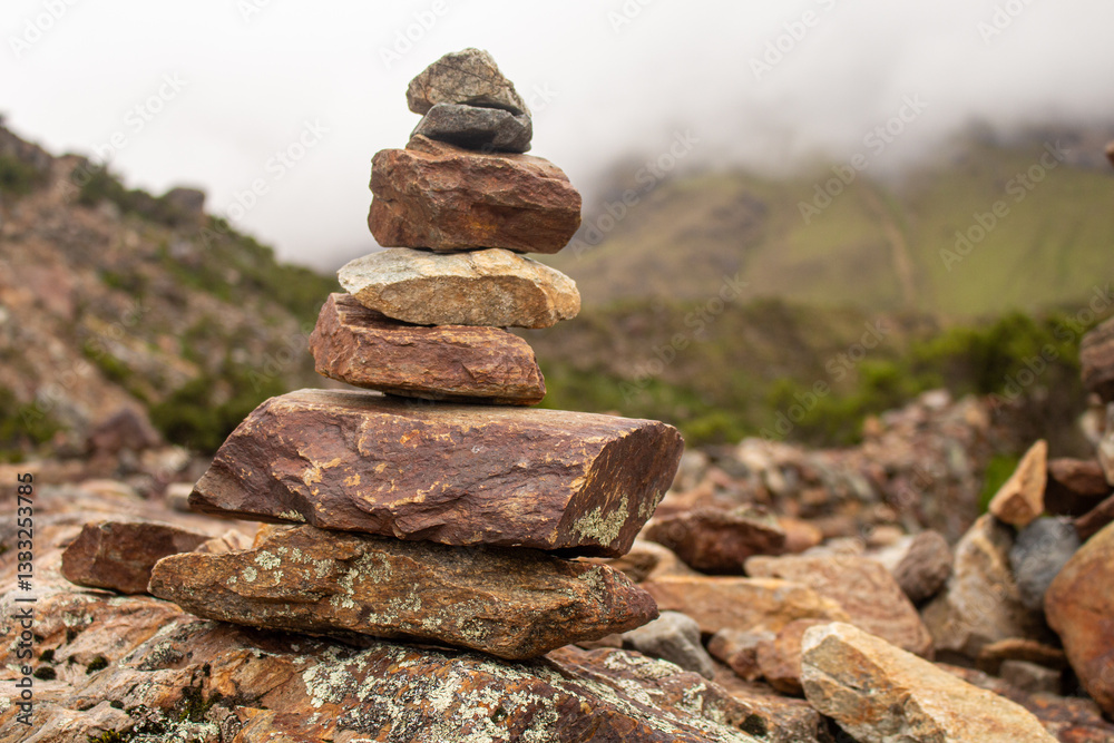 Balanced Stone Cairn in a nature scene with mountains and fog. Feeling of peace, balance and spirituality. Balanced Stone Cairn in a nature scene with mountains and fog. Feeling of peace, balance and spirituality.