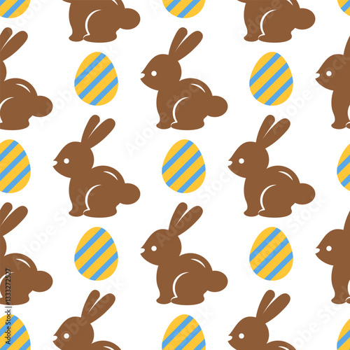 Easter seamless pattern with chocolate bunnies and yellow eggs on a white background. Pastel pattern with Easter rabbits. Cute background for greeting cards, baby textiles, wallpapers