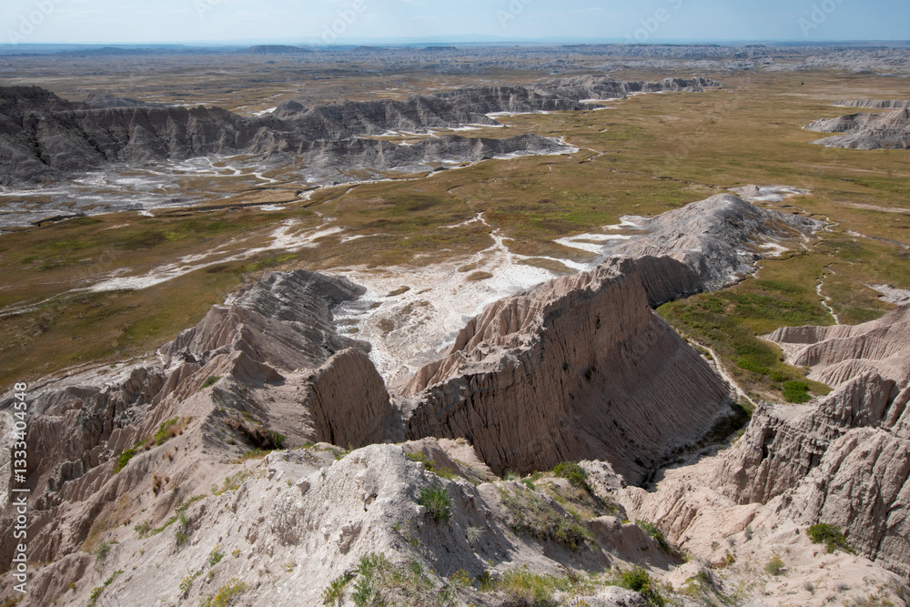 This breathtaking image captures the rugged terrain of the Badlands, showcasing unique rock formations and expansive plains under a bright, sunny sky. This breathtaking image captures the rugged terrain of the Badlands, showcasing unique rock formations and expansive plains under a bright, sunny sky.