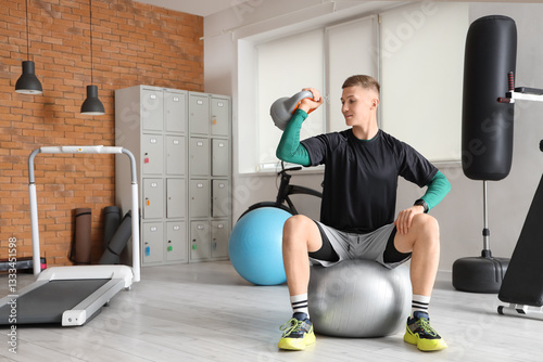 Young man exercising with a...