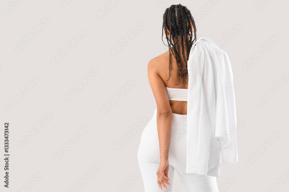 Stylish young woman with dreadlocks on light background, back view Stylish young woman with dreadlocks on light background, back view