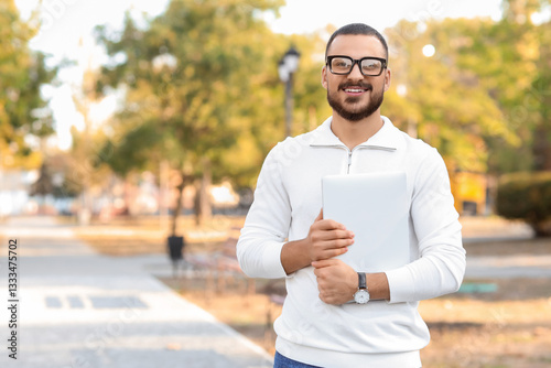 Young man with laptop in park
