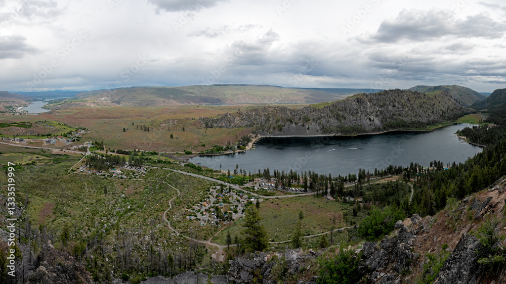 Obraz premium A breathtaking panoramic view showcasing serene valleys dotted with greenery and a tranquil lake, encapsulating the beauty and tranquility of nature in a gorgeous landscape.