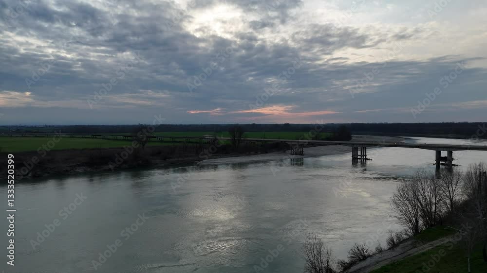 Aerial view capturing the Verdi Bridge over the Po River, connecting Seniga in Parma province with San Daniele Po in Cremona, highlighting Northern Italy's scenic beauty drone ascending shot Aerial view capturing the Verdi Bridge over the Po River, connecting Seniga in Parma province with San Daniele Po in Cremona, highlighting Northern Italy's scenic beauty drone ascending shot