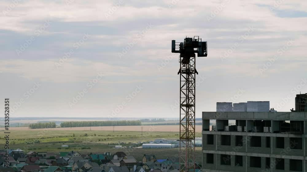 Construction of a multi-storey building. Tower crane operation. Construction of a multi-storey building. Tower crane operation.