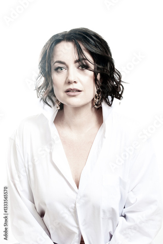 Portrait of a woman with dark hair, dressed in a white shirt, done in a high key.