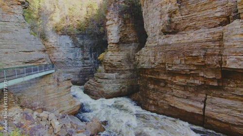 The Ausable River flows through the narrow gorge carved by Potsdam Sandstone in the heart of the Adirondack Park, New York. The stunning river view is surrounded by rugged cliffs.