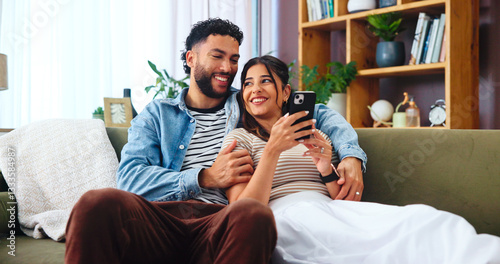 Couple, phone and social media in living room with hug, bonding and funny story in home. Woman, man and smartphone on sofa for storytelling, comedy and celebrity news on timeline with internet gossip