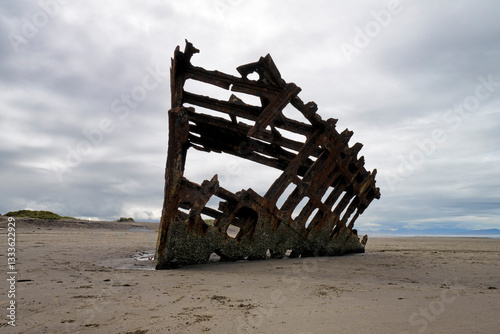 Foto An intriguing shipwreck stands dramatically on a deserted beach, evoking feelings of nostalgia and adventure while showcasing the passage of time in a captivating manner