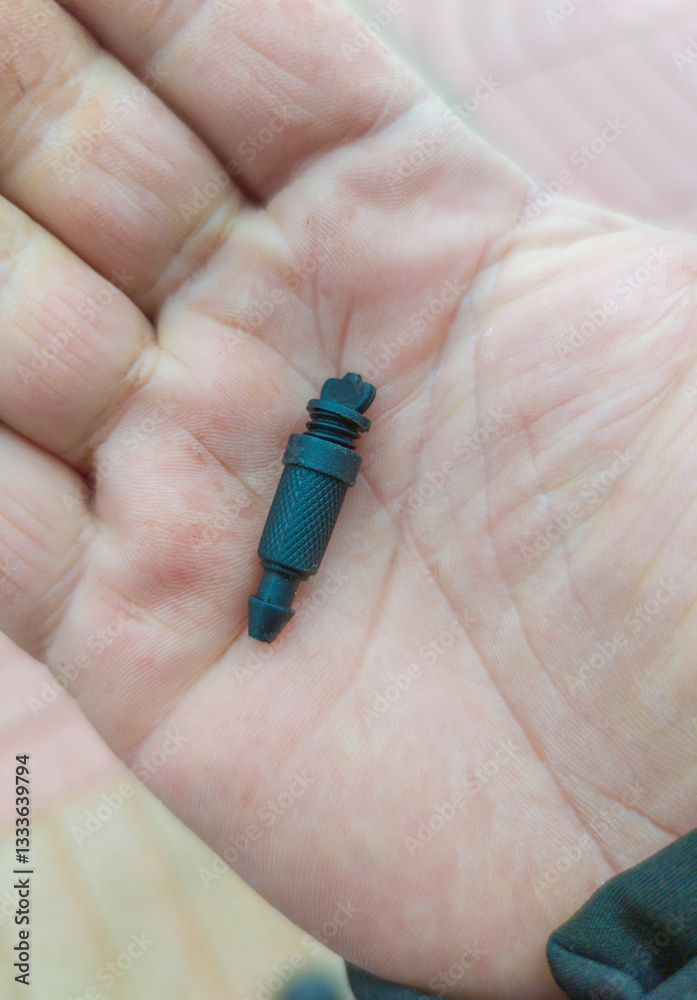 Adjustable dropper for irrigation system. Gardener shows watering equipment