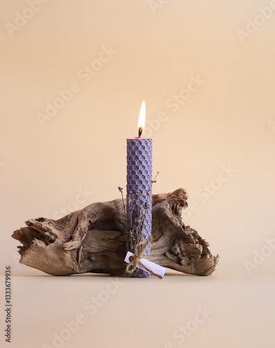 Photography Burning candle with a driftwood on a beige background, the concept of religion