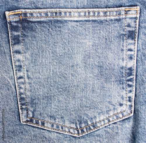 Blue jeans pocket close up. Details of jeans trousers with orange stitching