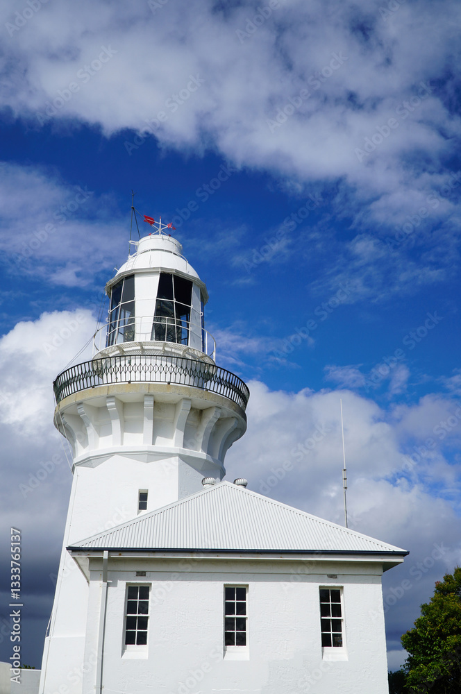 Historic Sandy Cape lighthouse under a partly cloudy vibrant blue sky Historic Sandy Cape lighthouse under a partly cloudy vibrant blue sky