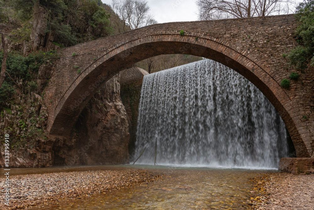 Palaiokarya stone arched bridge and waterfall near Pyli village, Thessaly, Greece