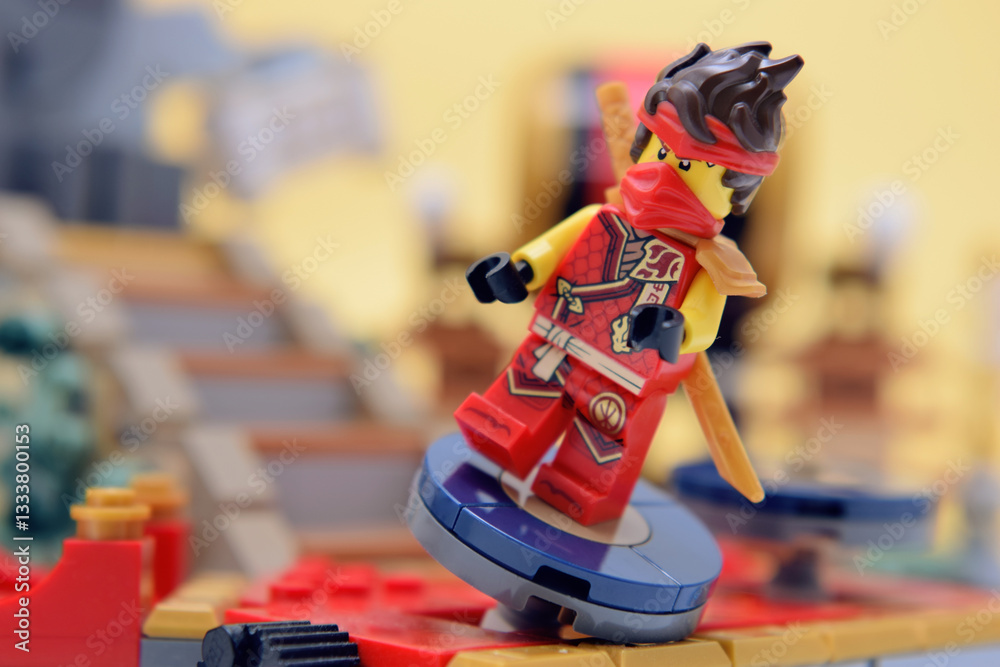 Naklejka premium Editorial illustrative image of lego ninjago minifigure of fire ninja Kai on training place.