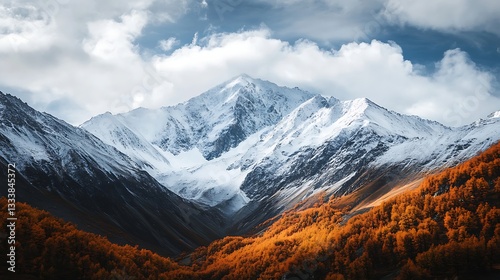 Snowy mountain peak with autumn foliage. Dramatic cloudscape. Scenic landscape.  Possible use Stock photo