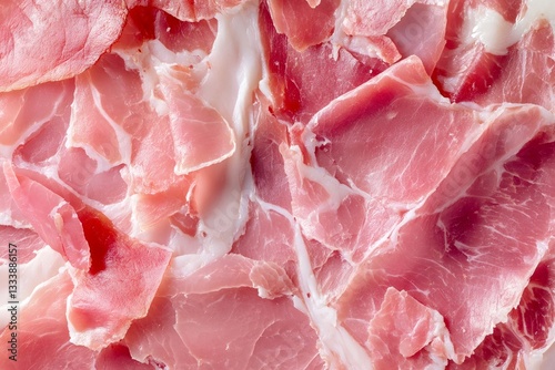 Close up of overlapping thin slices of ham, showcasing a smooth yet fibrous texture with a natural marble pattern
