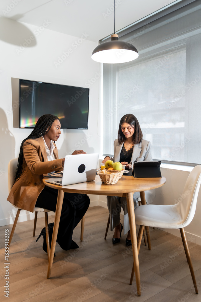Businesswomen working on laptops and tablets in hotel room Businesswomen working on laptops and tablets in hotel room