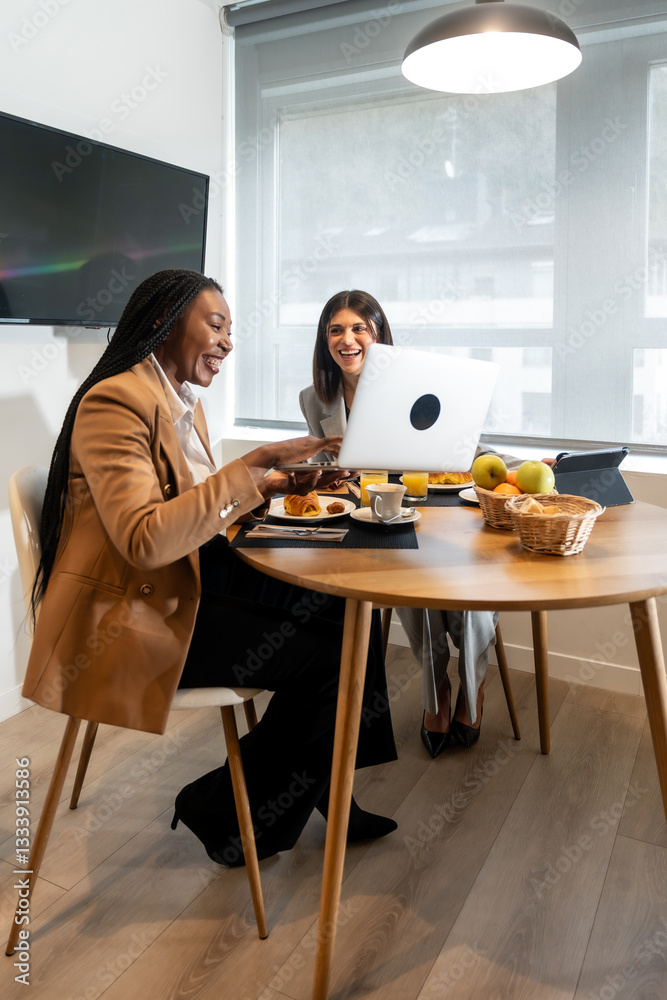 Businesswomen having breakfast and working on laptop in hotel room Businesswomen having breakfast and working on laptop in hotel room