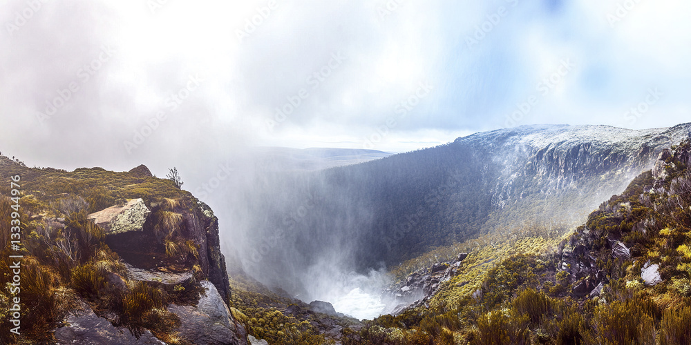 Misty view of waterfall in lush mountainous landscape Misty view of waterfall in lush mountainous landscape
