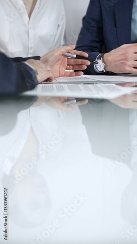Obraz na płótnie Unrecognizable business people are reviewing contract terms during a meeting while sitting at the glass table in office, vertical close up view. Copy space area w salonie