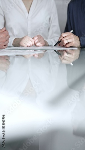 Business people are reviewing contract terms during a meeting, negotiating and making decisions together, vertical close up view. Copy space area